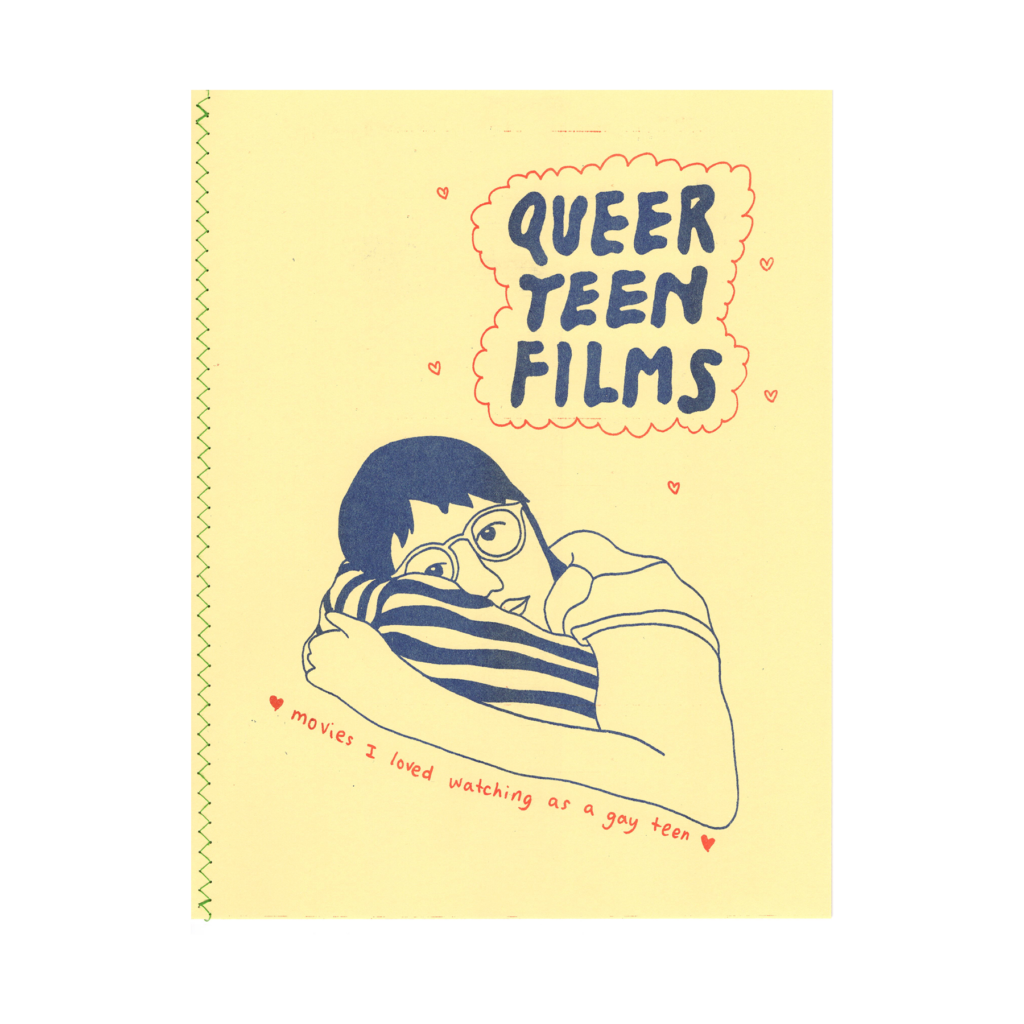 the cover of queer teen films zine, printed with dark blue ink, orange ink highlights, on cream colored paper. The title is drawn with filled in bubble letters, with a cloud outline around it. There are little hearts floating around the title. Below is an illustration of J laying down on a pillow, looking straight on, as if they were watching tv. Below the drawing are words that say, movies I loved watching as a gay teen.